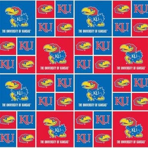 May include: A repeating pattern fabric featuring the University of Kansas Jayhawk mascot in blue, red, and yellow, alongside the letters KU and the text THE UNIVERSITY OF KANSAS, arranged in a grid of alternating blue and red square blocks.