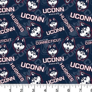 May include: A dark blue fabric featuring a repeating pattern of the white and blue UConn Huskies logo, the text UCONN HUSKIES, and UNIVERSITY OF CONNECTICUT, positioned above a white ruler showing 8 inches of length for scale and measurement.