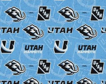 May include: A light blue fabric featuring a repeating pattern of the Utah Mammoth logo, the word Utah, and a stylized letter U. The design includes black and white graphics of a mammoth head and the text Utah Mammoth printed in black.