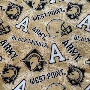 May include: A gold fabric featuring a repeating pattern of the Army Black Knights logo, the letter A, football helmets, and the text West Point. The design includes black and white graphics printed on a textured, mottled gold background.