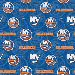 May include: A blue fabric featuring a repeating pattern of the New York Islanders NHL logo, which includes the letters NY, a hockey stick, and a puck, alongside the word ISLANDERS in orange text and additional faint circular logo graphics.