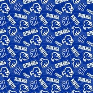May include: A blue fabric with a repeating pattern of white text and graphics. The text includes "Seton Hall" and "Pirates", along with the letters "SH" and a pirate head logo. The design is a mix of text and imagery.