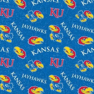 May include: A blue fabric featuring a repeating pattern of the Kansas Jayhawks mascot in yellow, red, and blue, alongside the white text KU and KANSAS JAYHAWKS. The design is printed on a textured blue background with a consistent sports theme.