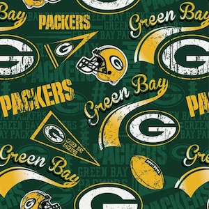 May include: A dark green fabric featuring a repeating pattern of Green Bay Packers logos, yellow football helmets, pennants, and footballs. The design includes distressed yellow and white text reading Packers and Green Bay, creating a sports-themed print.
