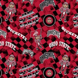 May include: Fabric featuring a repeating pattern of the Ohio State University mascot Brutus Buckeye, the text Ohio State, and the word Buckeyes on a red and black checkered background. The mascot is shown in a red and gray uniform with a flag.