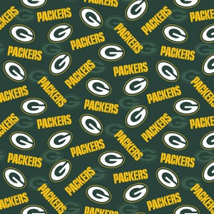 May include: A dark green fabric featuring a repeating pattern of the white and yellow Green Bay Packers logo and the word PACKERS printed in yellow block letters, arranged in various orientations across the surface of the material.