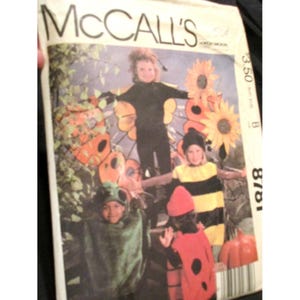 May include: Vintage McCall's sewing pattern featuring children in Halloween costumes. The costumes include a butterfly, bee, ladybug, and frog. The pattern cover has the McCall's logo and price.
