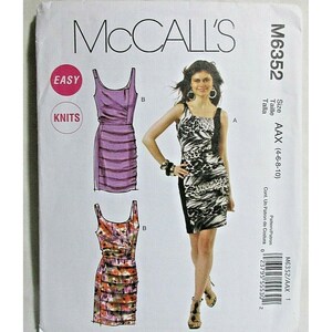 Puede incluir: Patrón de costura McCall's M6352 para vestidos. El patrón presenta tres diseños de vestidos, incluido un vestido fruncido morado y un vestido con estampado de animales en blanco y negro. El tamaño del patrón es AAX (4-6-8-10). La palabra "EASY" está en un círculo rosa.