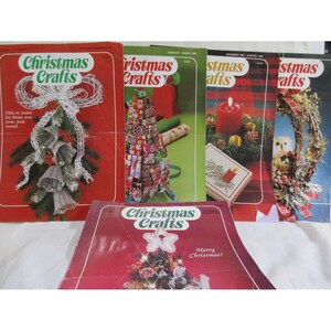 May include: Five vintage Christmas Crafts magazines with red covers and festive holiday imagery. The covers feature a variety of Christmas crafts, including wreaths, ornaments, and gift wrapping ideas. The magazines are titled "Christmas Crafts" and have the words "Merry Christmas!" printed on the front.