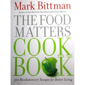 May include: A green cookbook with the title "The Food Matters Cookbook" by Mark Bittman. The book cover features a green apple with a bite taken out of it. The text on the cover reads "500 Revolutionary Recipes for Better Living."