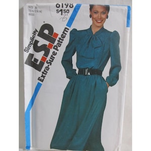 Może przedstawiać: Koperta z wykrojem krawieckim Simplicity ESP Extra-Sure Pattern 6198 przedstawiająca turkusową sukienkę z długim rękawem, wiązanym dekoltem, bufiastymi ramionami i czarnym paskiem. Wykrój jest przeznaczony dla rozmiarów 10, 12 i 14.