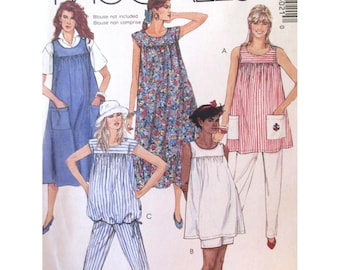 May include: A vintage McCall's sewing pattern showcasing several women's clothing designs. The patterns include a blue denim apron dress, a floral print dress, a striped top and trousers set, a white dress, and a red and white striped top with white trousers.
