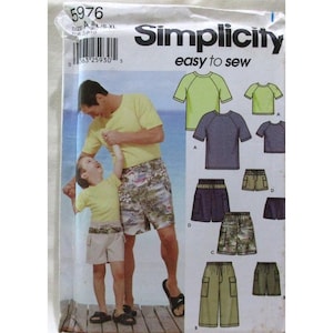 Puede incluir: Patrón de costura Simplicity 5976 para ropa de hombre y niño. El patrón incluye camisas de manga corta y pantalones cortos. El paquete presenta una foto de un padre y su hijo con la ropa puesta. El texto "easy to sew" es visible.