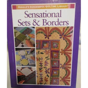 Könnte beinhalten: Ein Buch mit dem Titel "Sensational Sets & Borders" aus der Rodale's Successful Quilting Library. Das Cover zeigt einen Quilt mit floralen und geometrischen Mustern in Orange-, Grün- und Lilatönen. Der Einband des Buches ist von einem lila Rahmen umgeben.