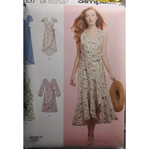 Puede incluir: Un sobre de patrón de costura Simplicity 8537 que muestra un vestido cruzado sin mangas con escote en V y estampado floral. El patrón incluye ilustraciones para cuatro variaciones del vestido, incluyendo opciones con mangas cortas y largas.