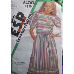 Puede incluir: Un sobre de patrón de costura Simplicity 6400 para un vestido con mangas abullonadas y cintura con cinturón. El patrón presenta un diseño de rayas verticales multicolores en tonos rosa, azul, verde y blanco. El texto incluye 6400, $1.75 y ADJUST-ABLE.