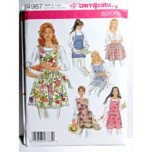 May include: Simplicity apron sewing pattern, number 4987, showcasing different apron designs. The cover displays illustrations of aprons with floral, checked, and patterned designs. The aprons have pockets and ties. The word "aprons" is visible.