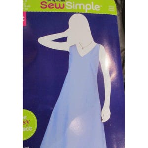 Pode incluir: Um padrão de costura Simplicity com um design de vestido azul claro com decote em V. A capa do padrão tem uma silhueta de uma pessoa vestindo o vestido. As palavras "Sew Simple" estão no topo.