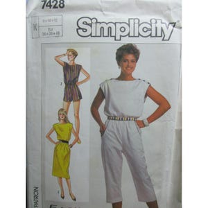 May include: Simplicity sewing pattern 7428 featuring a jumpsuit and dress. The pattern includes illustrations of a white jumpsuit with a striped belt, a striped romper, and a yellow dress. The pattern size is 8+10+12.