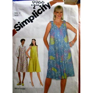 Può includere: Modello di cucito Simplicity per un abito da donna, taglia 12. Il modello presenta un abito blu con stampa floreale e altri due stili di abito. Il logo Simplicity è visibile nell'angolo in alto a sinistra.