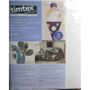 Puede incluir: Un paquete de entretela Timtex para proyectos de costura y manualidades. El paquete incluye un proyecto de marionetas gratuito y presenta una muñeca con un cuerpo en forma de cono púrpura. También muestra un bolso y un pavo real.