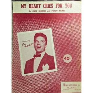 May include: Sheet music cover titled "My Heart Cries For You" by Carl Sigman and Percy Faith. Features a photo of Guy Mitchell. The cover is red with a textured pattern and includes the price of 40 cents.