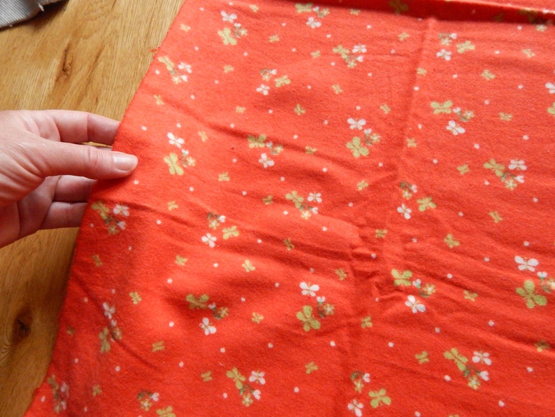 Puede incluir: Tela roja con un patr&oacute;n floral blanco y verde.