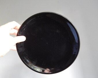 May include: A black ceramic dinner plate.