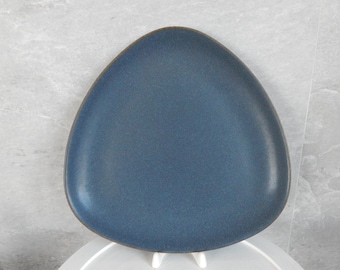 May include: A blue triangular ceramic plate with a smooth, slightly textured surface.