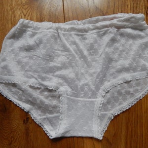 May include: White lace underwear with a delicate floral pattern and a white elastic waistband.