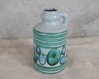 Könnte beinhalten: Eine kleine, hellblaue Keramikvase mit einem grün-blauen geometrischen Muster. Die Vase hat einen runden Körper und einen kleinen Henkel.