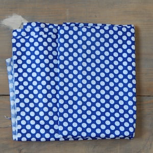 May include: A folded piece of blue fabric with white polka dots.