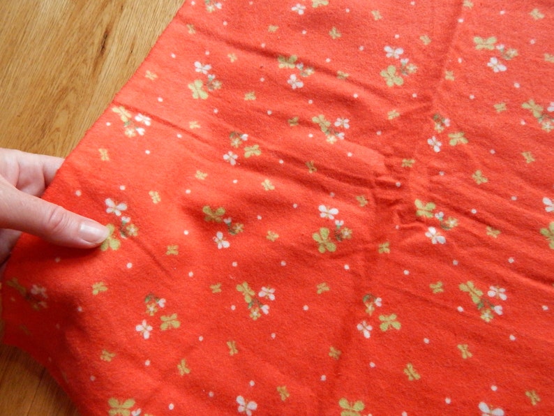 Puede incluir: Tela roja con un patr&oacute;n floral blanco y verde.