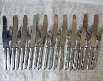 May include: A set of 18 silver-toned forks and knives with ornate handles. The handles have a floral design.