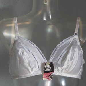 May include: White bra with a delicate lace trim and a small label that reads "Triola" on the front.