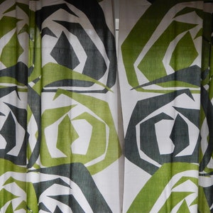 Puede incluir: Cortinas de tela blanca con un patrón geométrico de formas verdes y negras. El patrón se asemeja a una serie de círculos superpuestos.