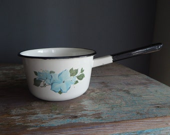 May include: White enamel saucepan with a black handle and a blue floral design.