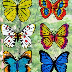 Pode incluir: Seis autocolantes de janela de borboletas coloridas. As borboletas apresentam vários designs, incluindo amarelo, vermelho, azul, branco e laranja. Cada borboleta tem um padrão único e é delineada em preto.
