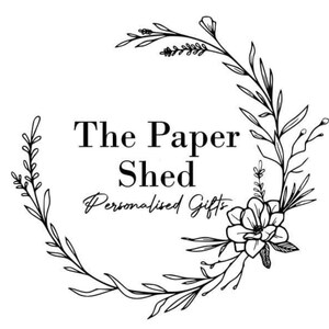 Pu&ograve; includere: Logo in bianco e nero per un'azienda chiamata "The Paper Shed" con lo slogan "Personalised Gifts". Il logo presenta una ghirlanda di fiori e foglie stilizzati.