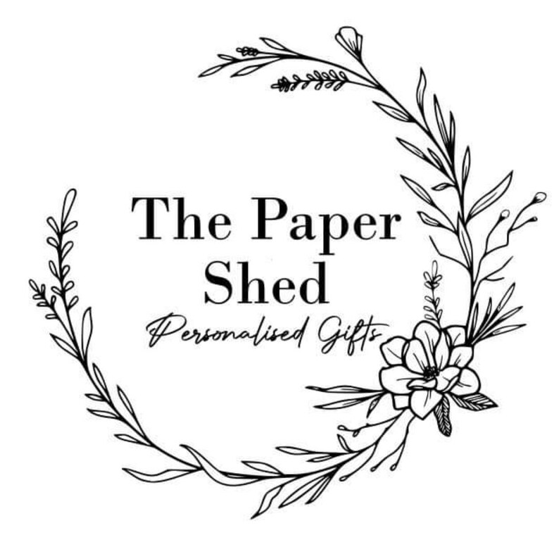 Pu&ograve; includere: Logo in bianco e nero per un'azienda chiamata "The Paper Shed" con lo slogan "Personalised Gifts". Il logo presenta una ghirlanda di fiori e foglie stilizzati.