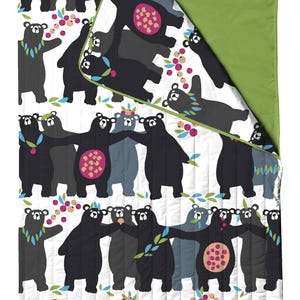 May include: A sleeping bag with a white background and a repeating pattern of black, gray, and blue bears. The bears have pink bellies and are holding hands. The sleeping bag has a green border and lining.