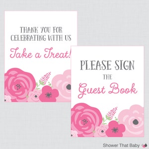 May include: Two white signs with floral designs and text. One sign reads "THANK YOU FOR CELEBRATING WITH US Take a Treat!" The other says "PLEASE SIGN THE Guest Book." Both have pink and white floral accents.