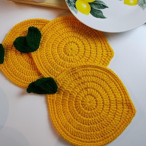 Pode incluir: Dois  copos de crochê em forma de limão amarelo com folhas de crochê verdes.