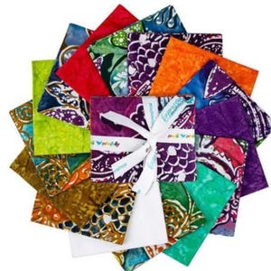 May include: A collection of square fabric swatches arranged in a circular fan pattern. The fabric pieces feature various batik-style patterns in vibrant colors including red, orange, purple, green, and brown, tied together with a white ribbon.