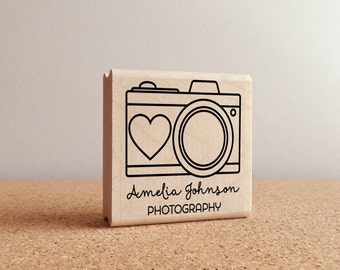 May include: Wooden stamp featuring a camera and heart design. The text "Amelia Johnson PHOTOGRAPHY" is printed below the image.
