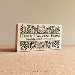 Custom rubber stamp impression reading "Hen & Harvest Farm – Naturally Raised · Farm Fresh" stamped in black ink on the inside lid of a green egg carton, shown with a dozen fresh brown eggs. Perfect for backyard chicken keepers, small farms, and handmade packaging.