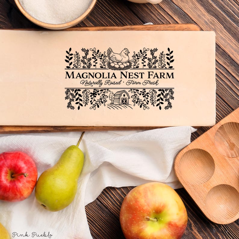 Custom rubber stamp impression reading "Hen & Harvest Farm – Naturally Raised · Farm Fresh" stamped in black ink on the inside lid of a green egg carton, shown with a dozen fresh brown eggs. Perfect for backyard chicken keepers, small farms, and handmade packaging.