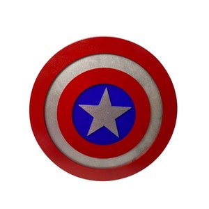 May include: A red, white, and blue circular shield with a silver five-pointed star in the center. The shield has a concentric circle design.