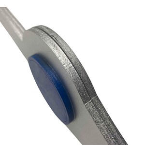 May include: Close-up of a silver-coloured metal tool with a blue rubber grip. The tool has a curved shape and a flat edge.