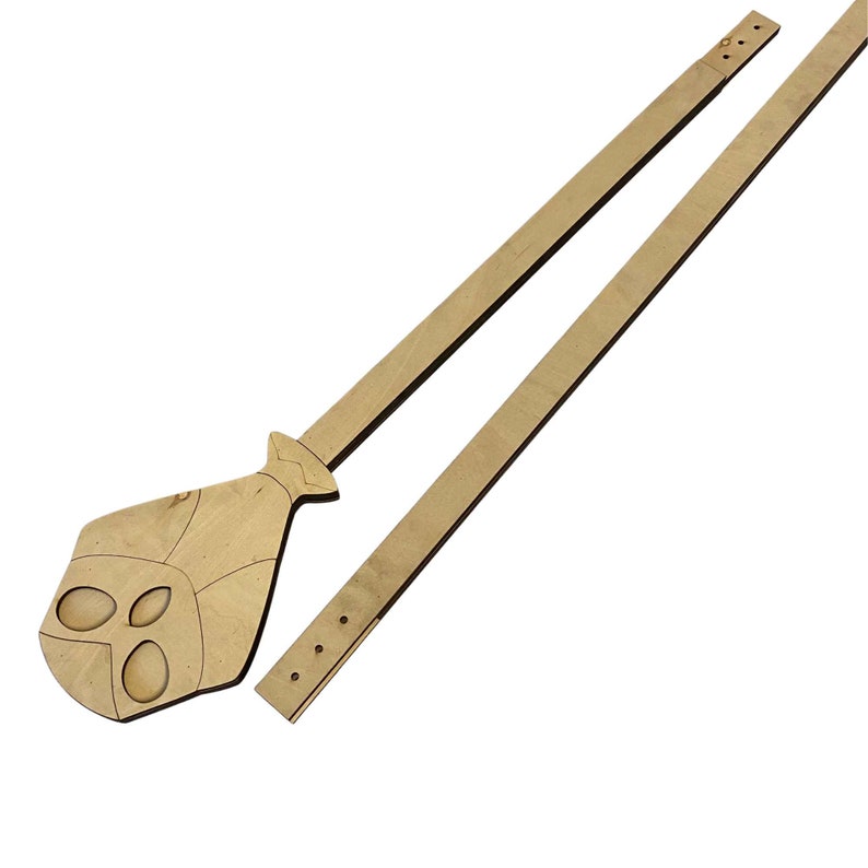 K&ouml;nnte beinhalten: Zwei Holzst&uuml;cke f&uuml;r ein DIY-Bastelprojekt. Ein St&uuml;ck ist ein langer, d&uuml;nner Holzstreifen mit gebohrten L&ouml;chern. Das andere St&uuml;ck ist in Form eines Sch&auml;dels mit einer Krawatte.
